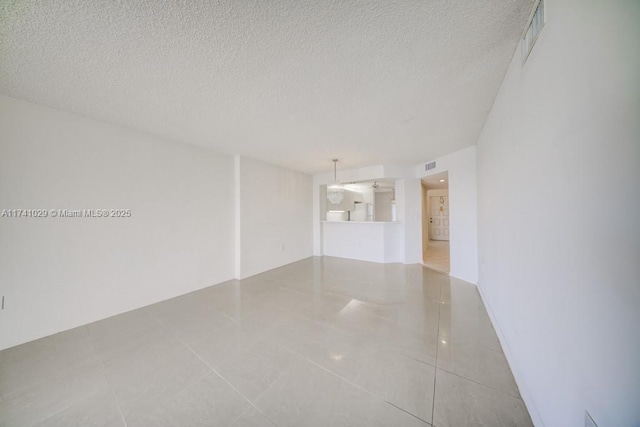unfurnished room featuring tile patterned flooring and a textured ceiling