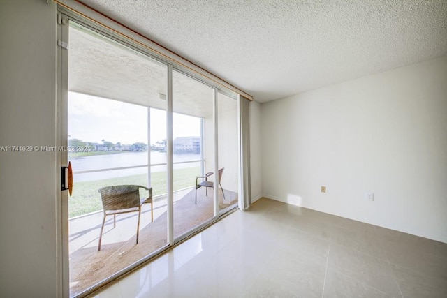 spare room featuring a water view, floor to ceiling windows, and a textured ceiling