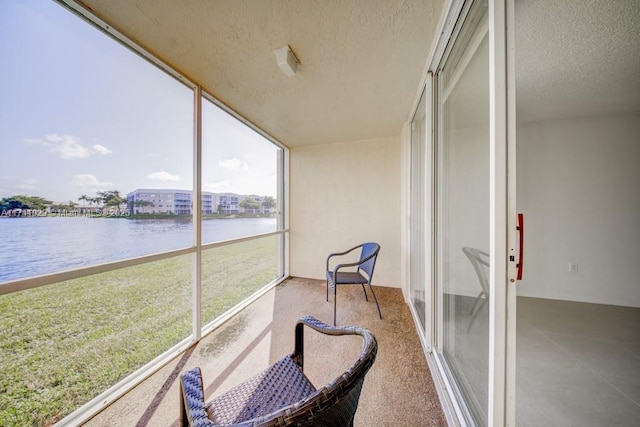 sunroom featuring a water view
