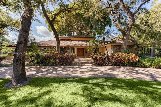 ranch-style home featuring a front lawn