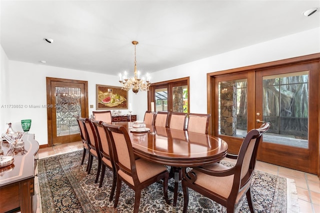 tiled dining area featuring an inviting chandelier and french doors