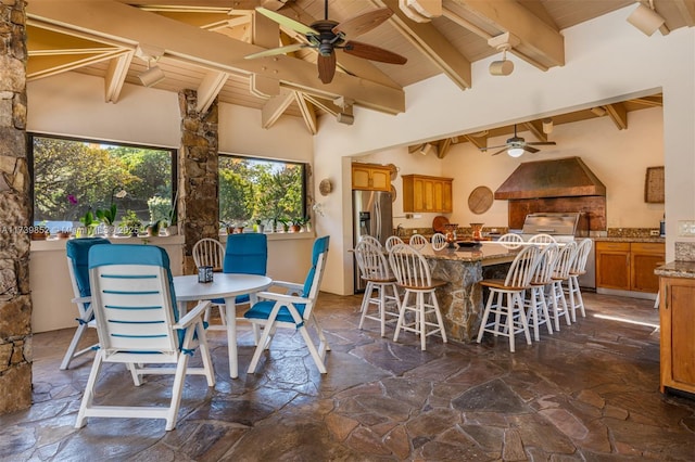 dining area featuring vaulted ceiling with beams, wood ceiling, and ceiling fan