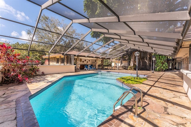 view of swimming pool featuring a patio and glass enclosure