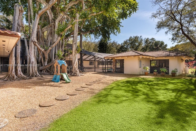 exterior space featuring a lanai and a lawn