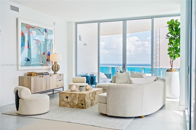 living room featuring a water view and a wall of windows