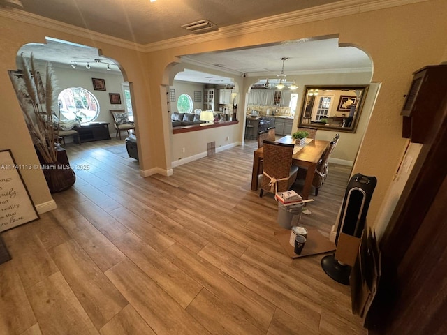 dining space featuring crown molding and light hardwood / wood-style flooring