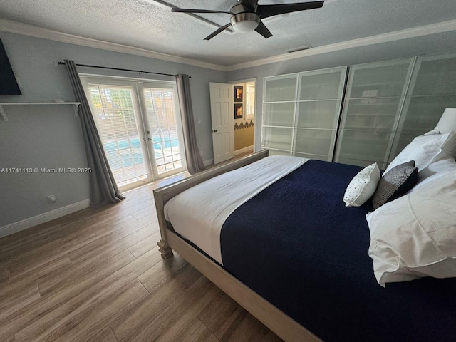 bedroom with hardwood / wood-style flooring, ornamental molding, access to exterior, ceiling fan, and a textured ceiling