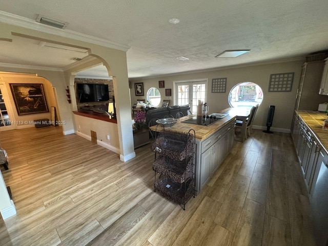 kitchen featuring french doors, a textured ceiling, light wood-type flooring, gray cabinets, and black electric stovetop