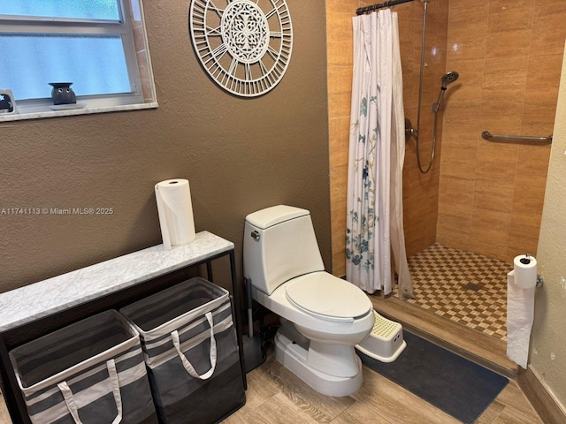 bathroom featuring toilet, hardwood / wood-style floors, and a shower with curtain