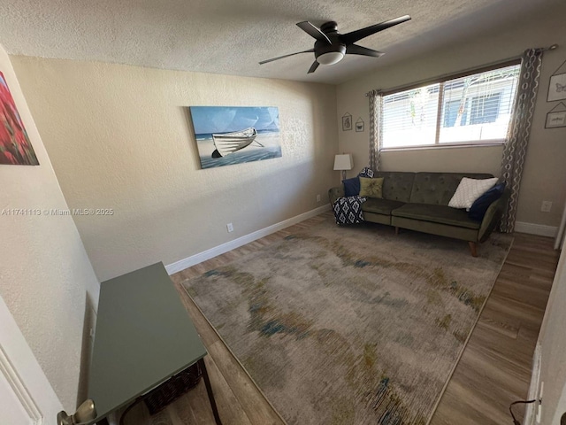 living room featuring hardwood / wood-style floors, a textured ceiling, and ceiling fan