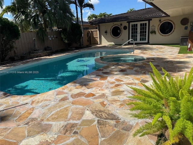 view of pool with a patio, central AC unit, french doors, and an in ground hot tub