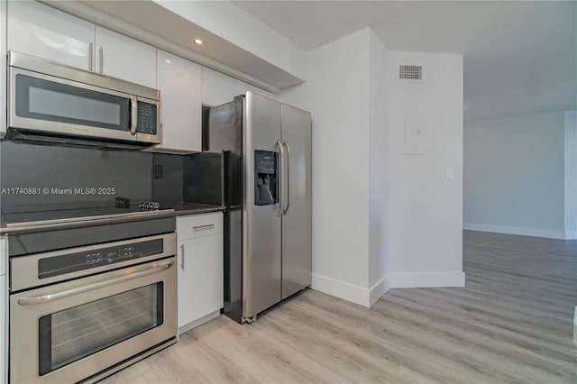 3530 Mystic Pointe Dr Unit 1513, Aventura, FL 33180 - kitchen with stainless steel appliances, white cabinets, and light hardwood / wood-style floors