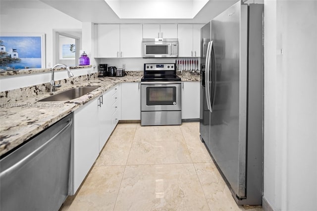 kitchen with sink, appliances with stainless steel finishes, white cabinetry, light stone countertops, and light tile patterned flooring