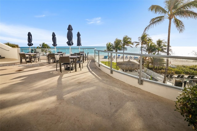 view of patio featuring a view of the beach and a water view