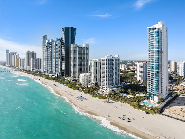 birds eye view of property featuring a water view and a beach view