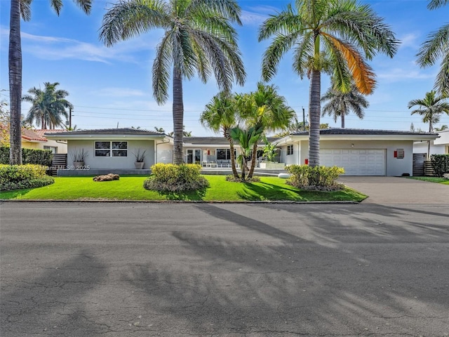 single story home with a garage and a front lawn