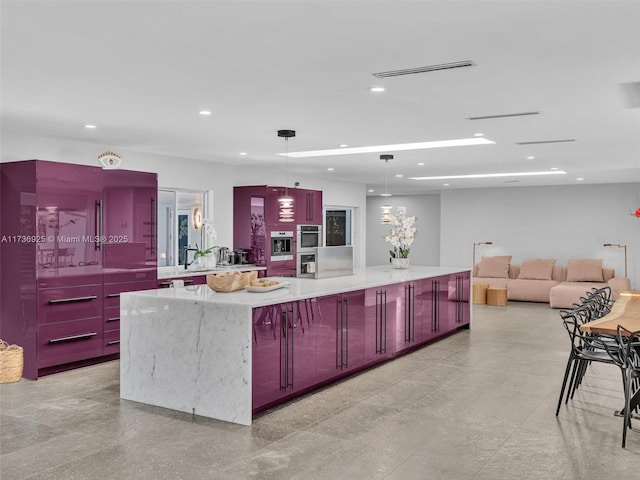 kitchen with a large island, light stone counters, pendant lighting, and double oven