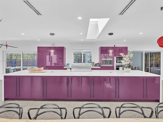 kitchen with pendant lighting, double oven, and a spacious island