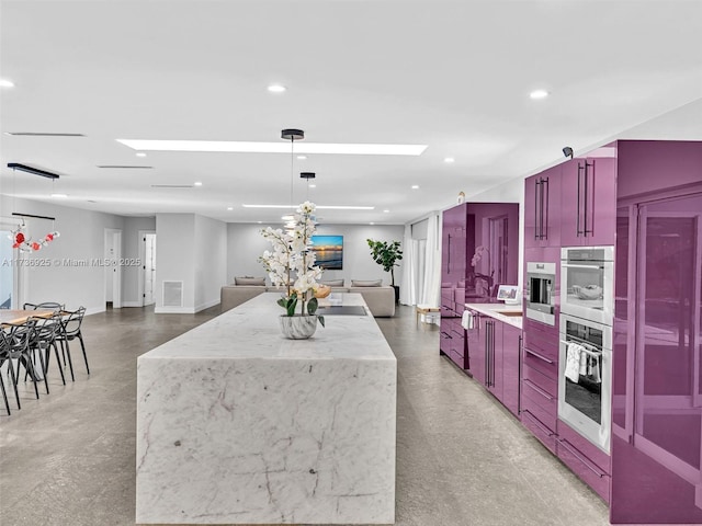 kitchen with a large island, pendant lighting, concrete floors, and light stone counters