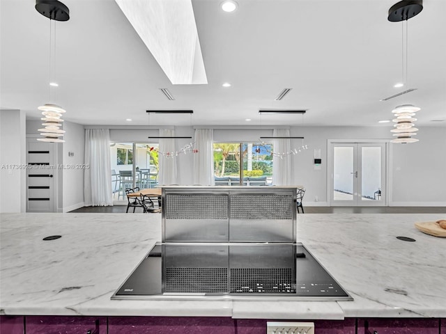 kitchen featuring hanging light fixtures, light stone countertops, and french doors