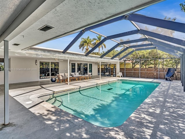 view of swimming pool with an outdoor living space, a lanai, and a patio area