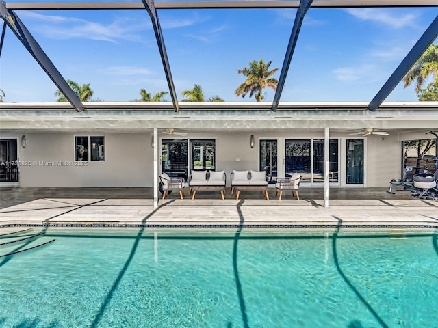 view of swimming pool featuring ceiling fan, an outdoor hangout area, a patio, and a lanai