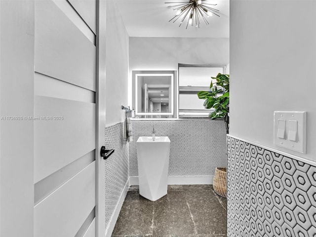 bathroom featuring tile walls and a notable chandelier