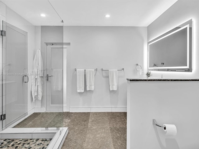 bathroom featuring vanity and a shower with door