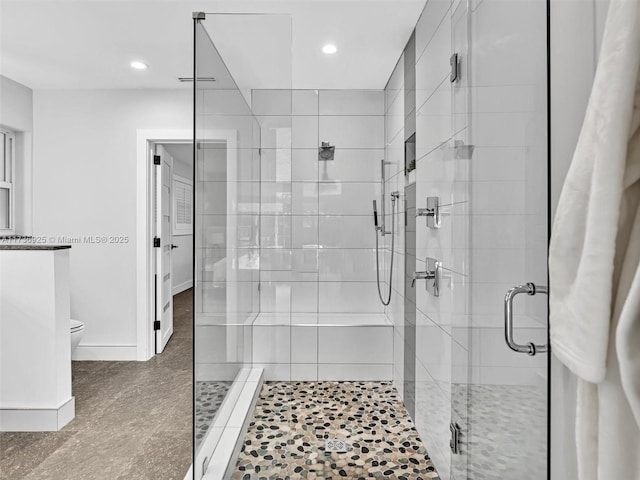 bathroom with a shower with shower door and toilet