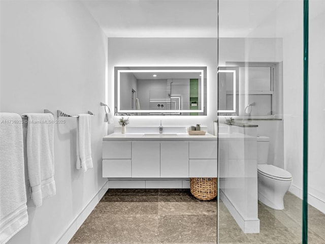 bathroom featuring vanity, toilet, and a shower