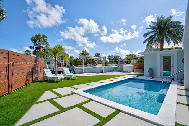 view of swimming pool featuring a yard, a patio, and a jacuzzi