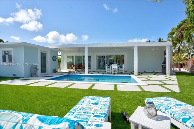 rear view of house with ceiling fan, a yard, and a patio area