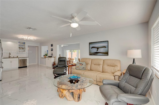 living room featuring ceiling fan, marble finish floor, visible vents, and baseboards