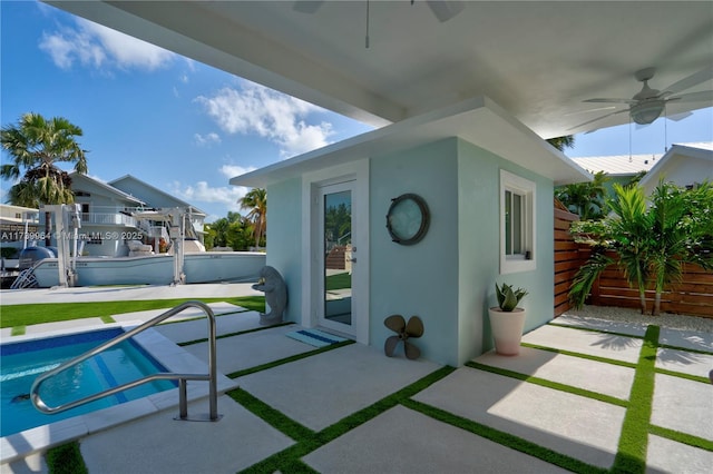 view of patio / terrace featuring an outdoor pool, ceiling fan, and fence