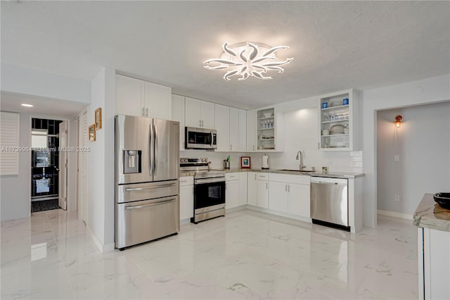 kitchen featuring white cabinetry, glass insert cabinets, stainless steel appliances, and light countertops