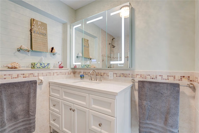 full bathroom featuring wainscoting, tile walls, and vanity