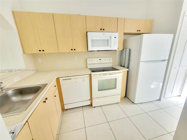 kitchen featuring light tile patterned flooring, white appliances, light brown cabinetry, and sink