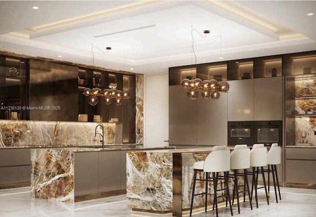 bar featuring sink, a tray ceiling, black oven, and dark stone counters