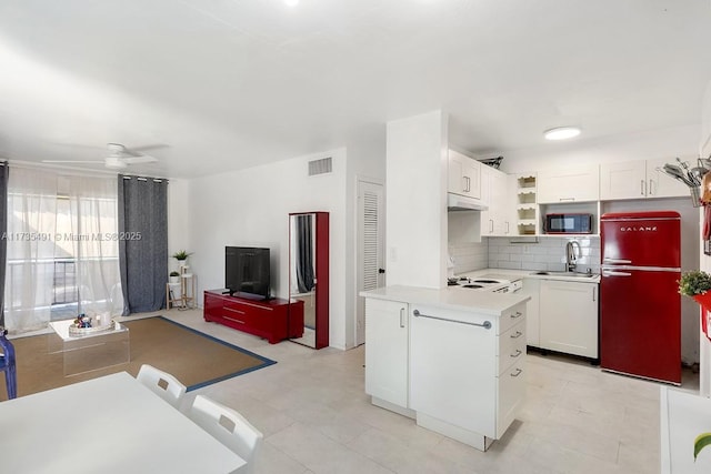 kitchen featuring sink, ceiling fan, refrigerator, white cabinetry, and tasteful backsplash