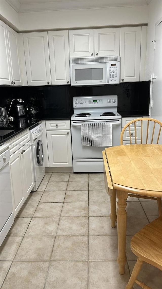 kitchen featuring light tile patterned flooring, washer / dryer, white cabinetry, tasteful backsplash, and white appliances