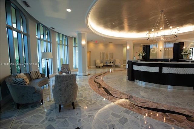 reception area with a chandelier and decorative columns