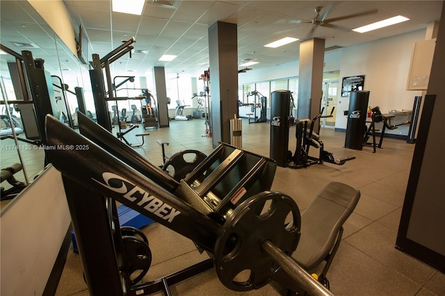 workout area featuring ceiling fan and a paneled ceiling