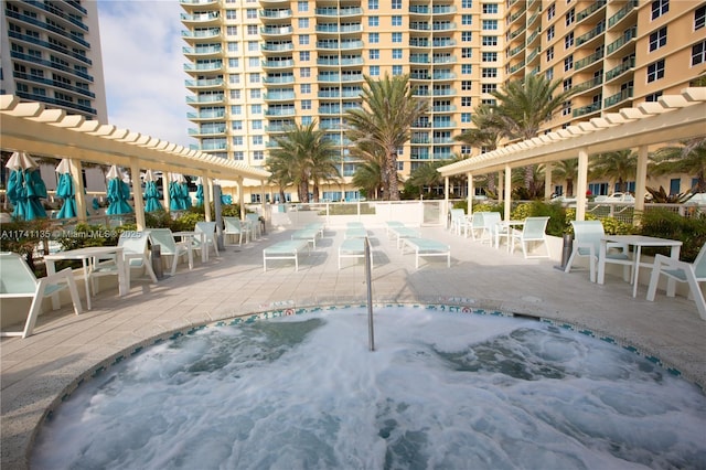 view of swimming pool featuring a community hot tub and a pergola