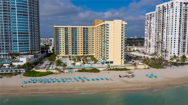 view of building exterior featuring a water view and a view of the beach