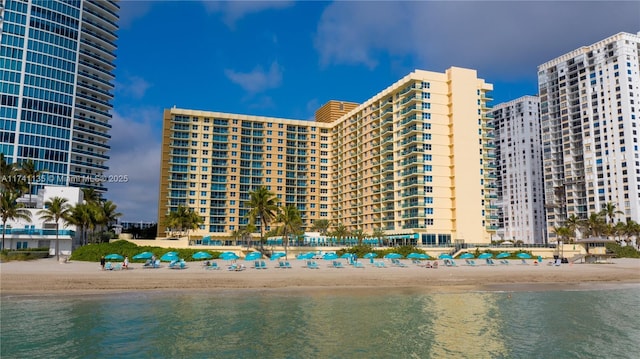 view of building exterior featuring a beach view and a water view