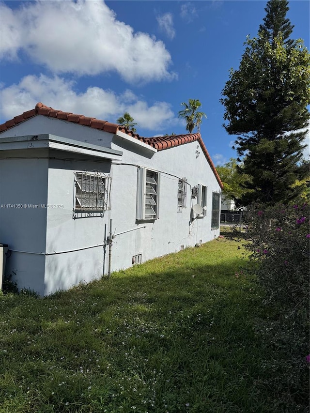 view of property exterior featuring a lawn