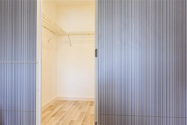 spacious closet with light hardwood / wood-style floors