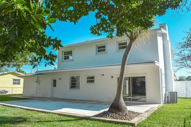 rear view of property featuring central AC unit, a yard, and a patio area