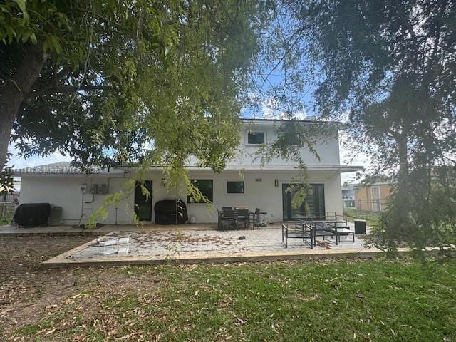 back of property with a patio and a lawn