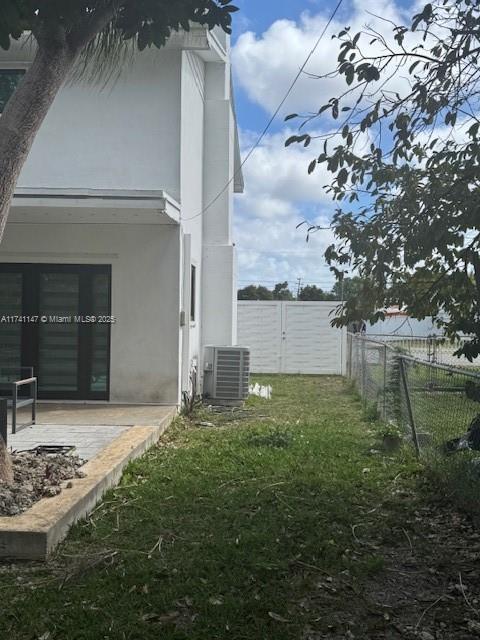 view of yard with central AC and a patio area